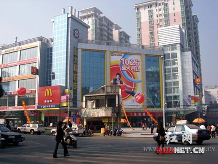 长沙市南门口广场的绿化带位置，“钉子户”与身后的商场形成强烈的反差 ...