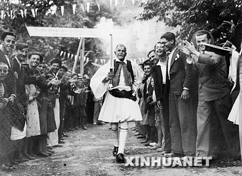 图为在1936年奥运会火炬接力起跑仪式中，一位身着传统民族服装的希腊老人在观众的喝彩声中起跑。   ...