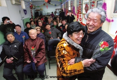 昨天（13日），高大爷与老伴练习情人节如何送花和拥抱。 记者王磊摄