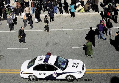 这个非法劳务市场附近的马路上，不时有负责当地治安的巡逻警车经过。