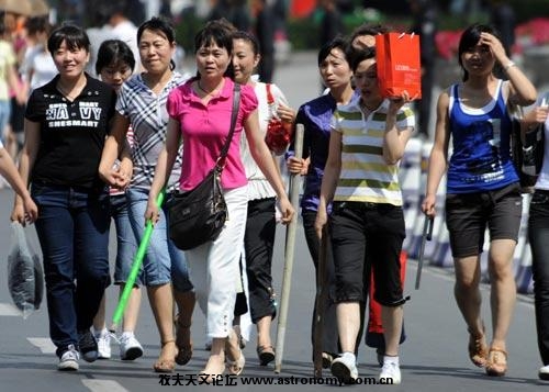 7月7日下午，在乌鲁木齐市人民广场街道上行走的汉族妇女，个个手持木棒自卫。 ... ...