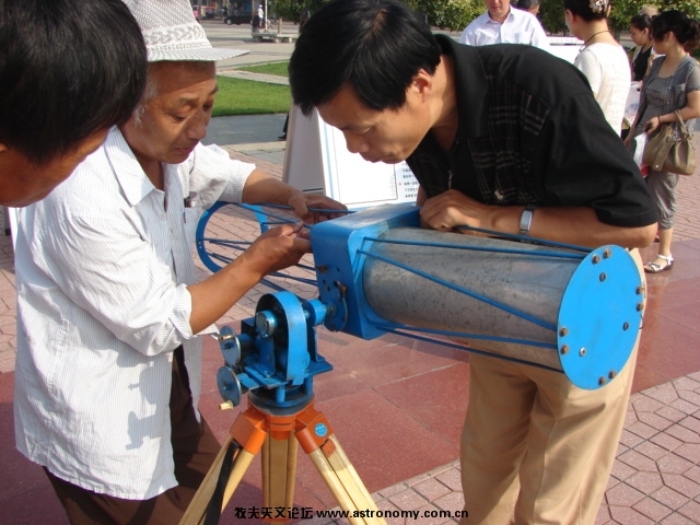 在科技馆徐文庆的协助下组装望远镜