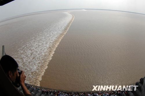 10月6日，一名摄影师在浙江海宁拍摄观潮胜景